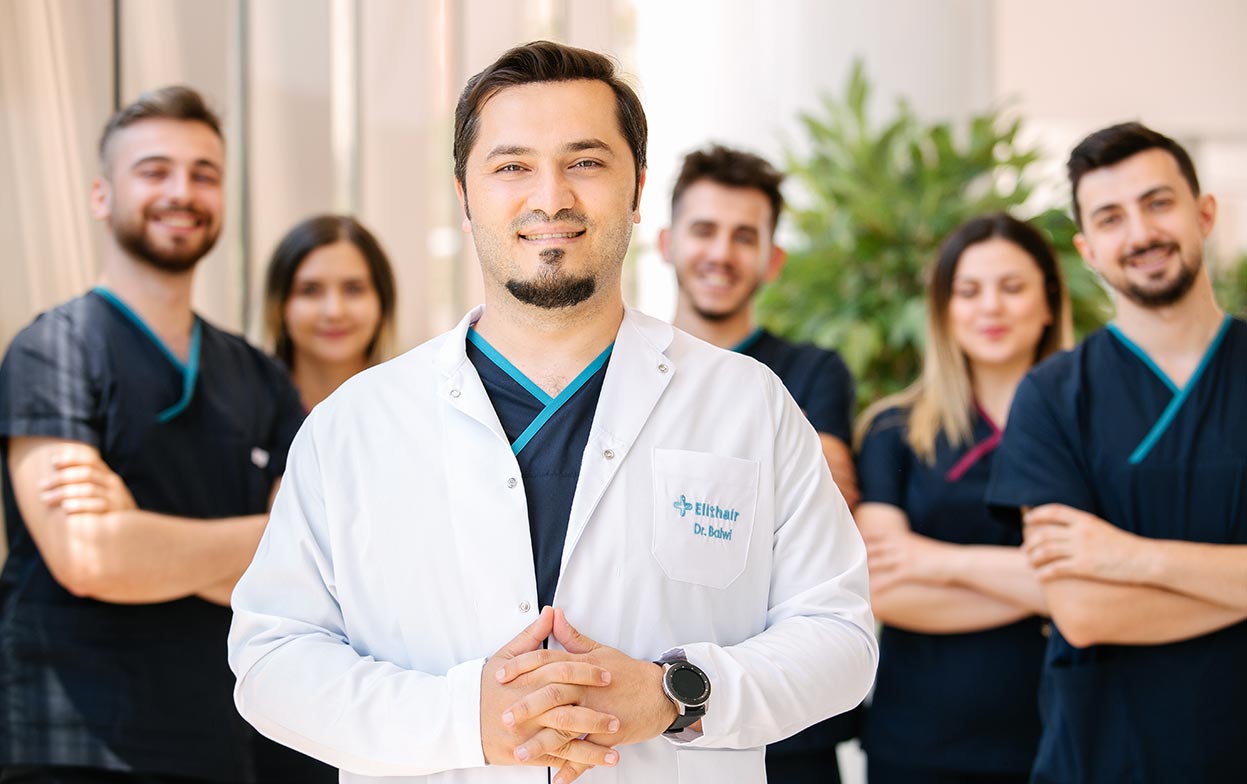 Il Dr. Balwi sorridente insieme al suo team medico di Elithair